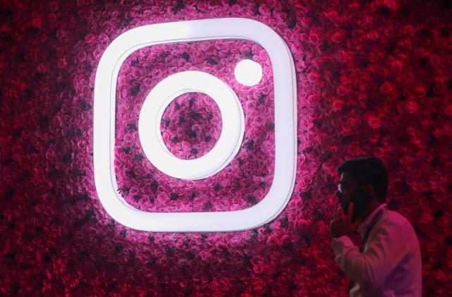 A man talks on the mobile phone next to a logo of Instagram, during a Meta event in Mumbai, India, 20 September, 2023. (Photo by Niharika Kulkarni/NurPhoto via Getty Images)
