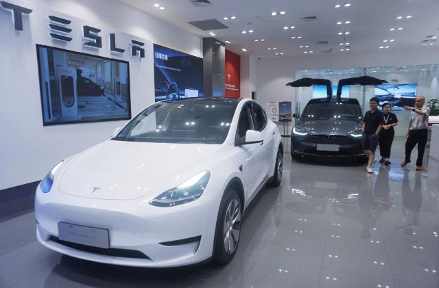 HANGZHOU, CHINA - AUGUST 14, 2023 - Customers buy electric cars at a Tesla store in Hangzhou, East China's Zhejiang province, Aug. 14, 2023. On the same day, Tesla announced that it had lowered the price of its two high-end Model Y models in the Chinese market, reducing the price of each car by $1,900 (about 14,000 yuan), and also announced an 8,000 yuan limited time insurance subsidy for existing Model 3 car orders. (Photo credit should read CFOTO/Future Publishing via Getty Images)
